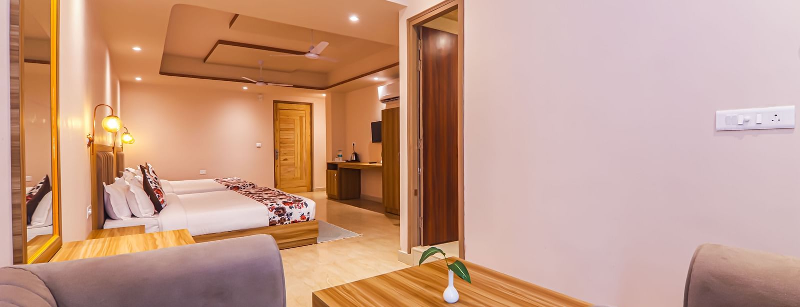 A cosy living area connects to a bedroom with multiple beds at Vedikant Resorts The Mallard Corbett.
