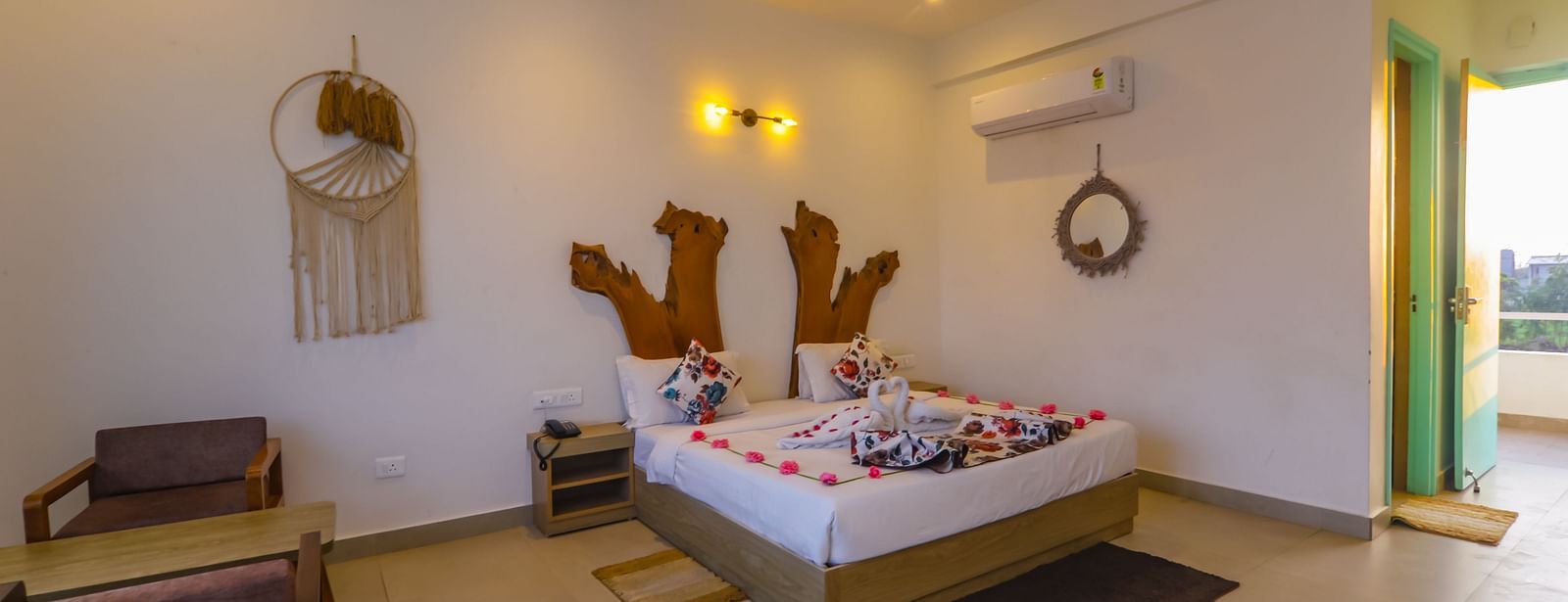 A bright bedroom at Vedikant Resorts The Mallard Corbett features a decorated bed and comfortable seating.