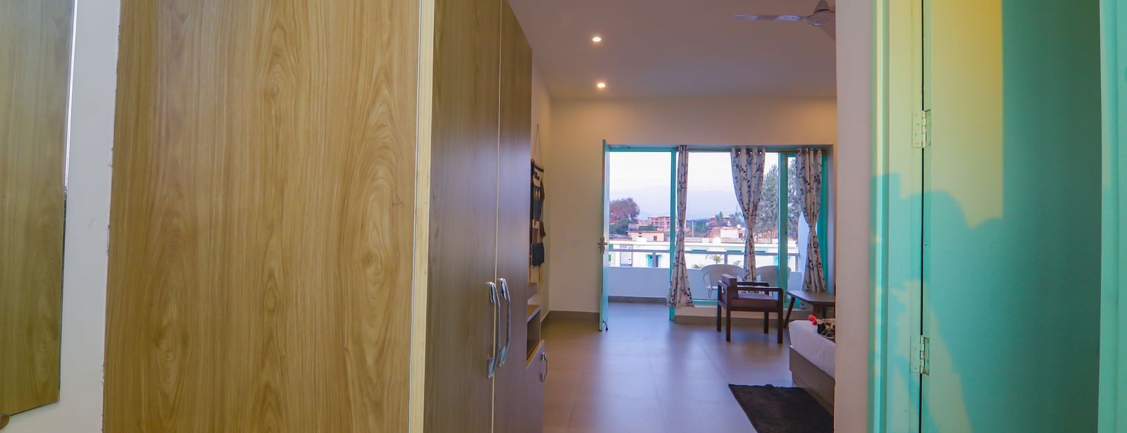 An open doorway reveals a bedroom with a view from inside Vedikant Resorts The Mallard Corbett.