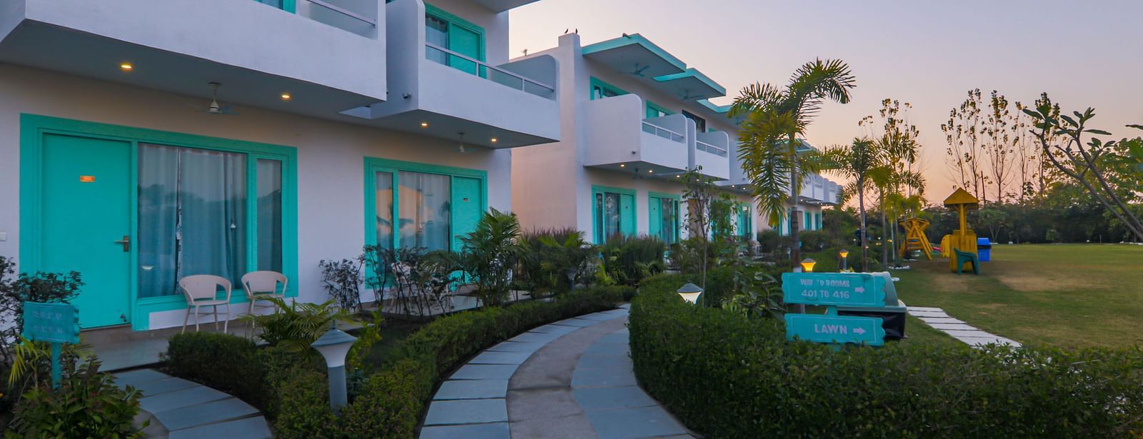 Exterior view of buildings and landscaped grounds at Vedikant Resorts The Mallard Corbett at dusk.