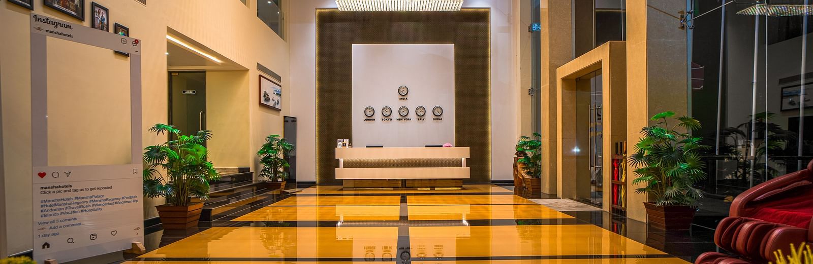 A brightly lit hotel hallway with polished floors and plants | Mansha Hotels