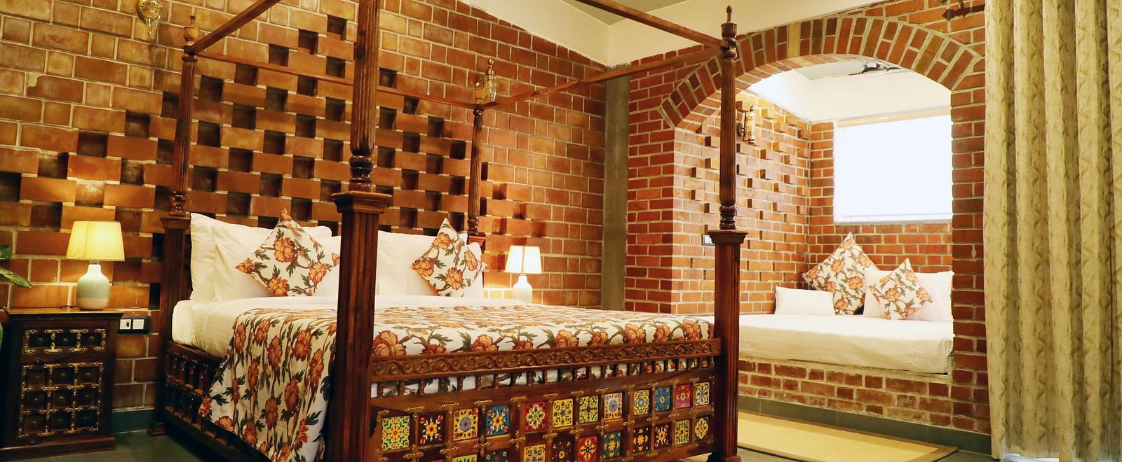 A bedroom with a bay window bed and a lamp beside it at Tisya Farms, Gurgaon.