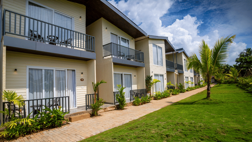 facade image featuring the exterior of sibaya beach resort, morjim beach with green lawn in front of it