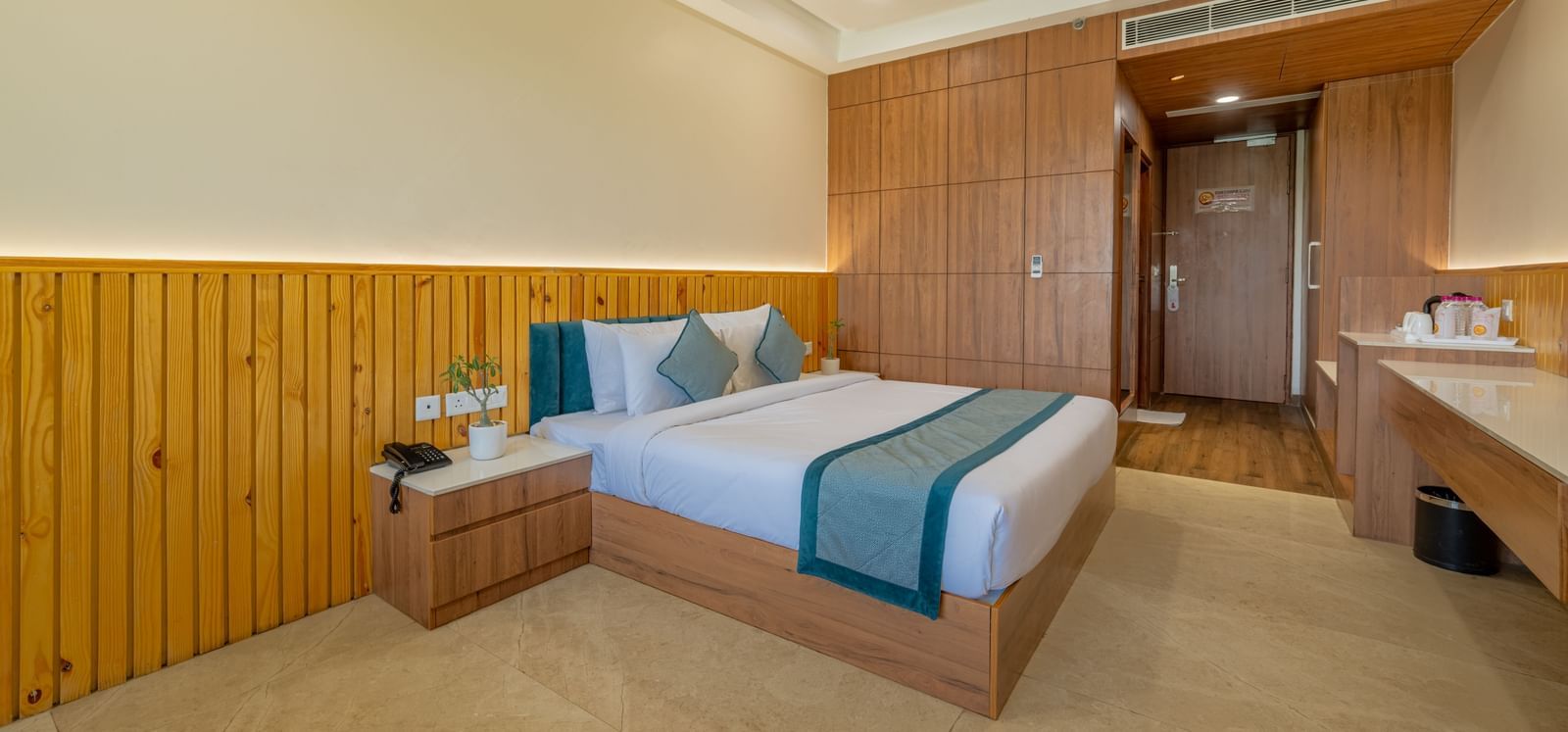 Elegant bedroom with ceiling fan, side table, and wardrobe setup in an executive king room at Hotel Highway, Bagru.
