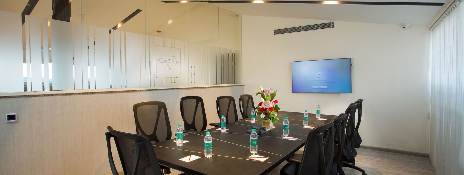 Another angle of the conference room showing a glass partition and a whiteboard - De Venetian by TGI, Brookefield
