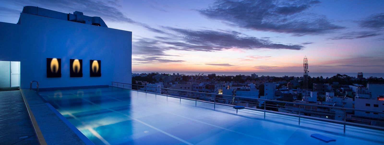 view of a swimming pool at sunset at Hotel Atithi - TGI Grand, Pondicherry