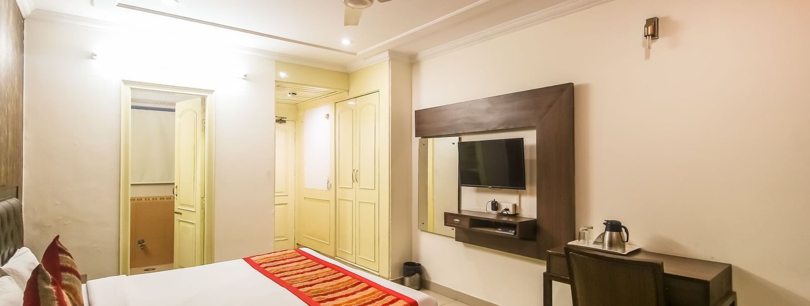 Room view with bed, writing desk and entryway at Hotel Diamond Plaza, Chandigarh