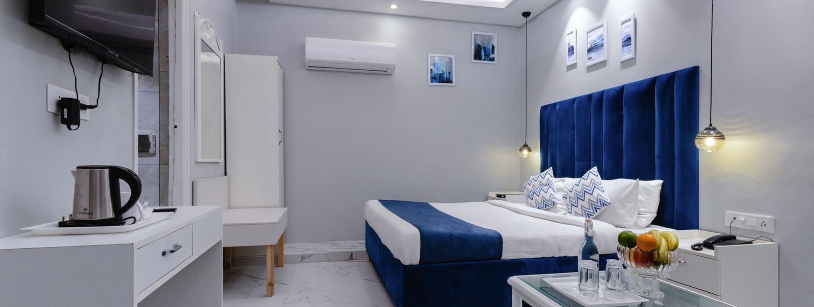 Stylishly lit hotel room with modern furniture, white tones, and elegant textiles at Hotel Downtown17, Chandigarh.