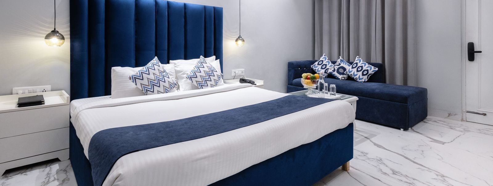 Hotel room featuring a royal blue headboard, plush bedding and a soft lighting at Hotel Downtown17, Chandigarh.
