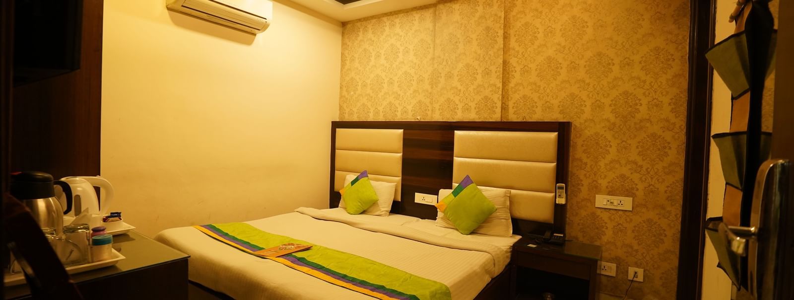 Standard Room at Hotel Dreamland, Chandigarh with king-size bed, bedside table, TV, single chair and air conditioning.