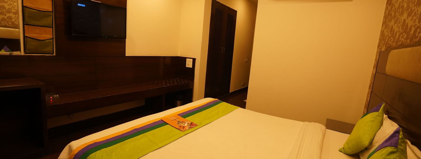 Wooden-floored Deluxe room with King-size bed, wall-mounted TV, air-conditioning and quality linens at Hotel Dreamland, Chandigarh