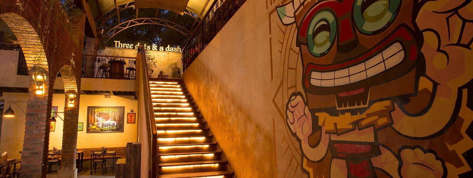 a staircase leading upstairs with graffiti on the wall beside the staircase - Hotel Fountain Tree By TGI - JP Nagar, Bangalore
