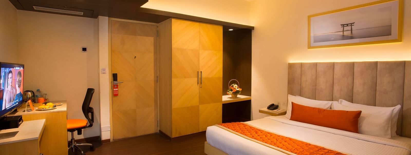 A spacious hotel room with a comfortable bed, ambient lighting and a television, featuring a wooden wardrobe and desk - Hotel Langford Keys by TGI, Shanti Nagar