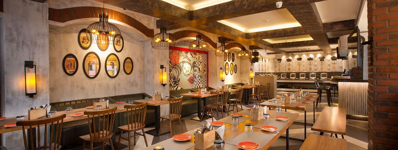 A cosy restaurant interior with wooden tables, pendant lighting and a buffet area in the background - Hotel Southend by TGI - Bommasandra, Bangalore