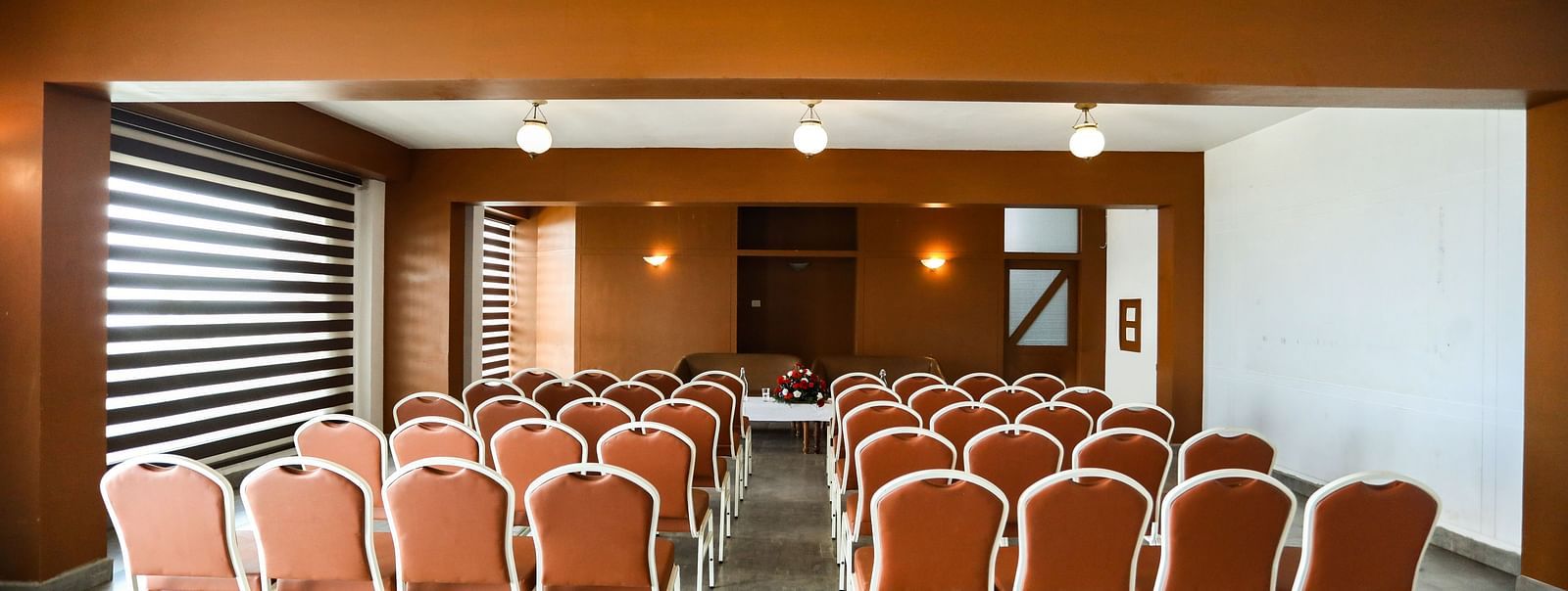 brown and white chairs placed in the banquet hall of La Montana By TGI, Ooty