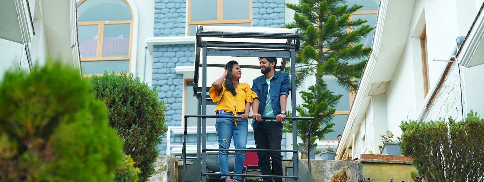 a man and woman standing on a yellow platform at La Montana By TGI, Ooty