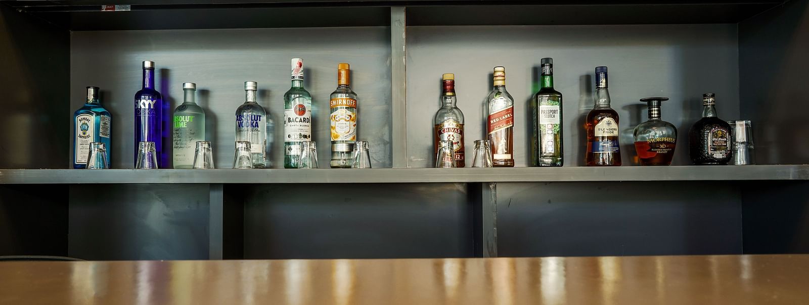 Close-up view of liquor bottles on a bar shelf - TGI Ameya Grand, Goa