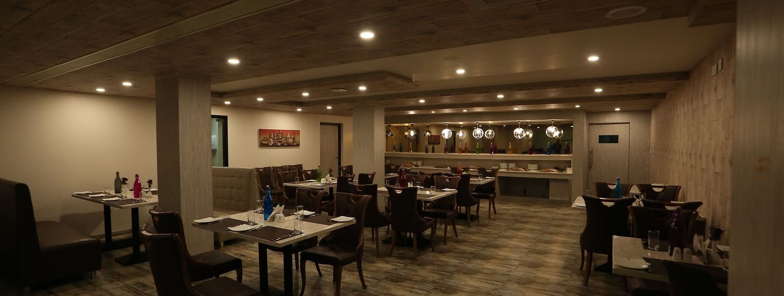 A restaurant with tables and chairs, designed with warm lighting and a cosy ambience - TGI SPS Grand, Coimbatore