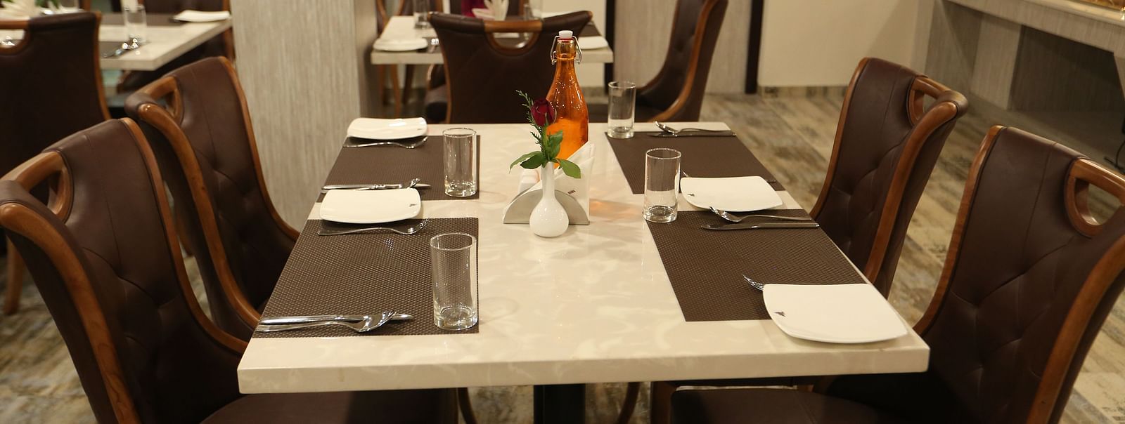 A dining area with set tables surrounded by chairs - TGI SPS Grand, Coimbatore