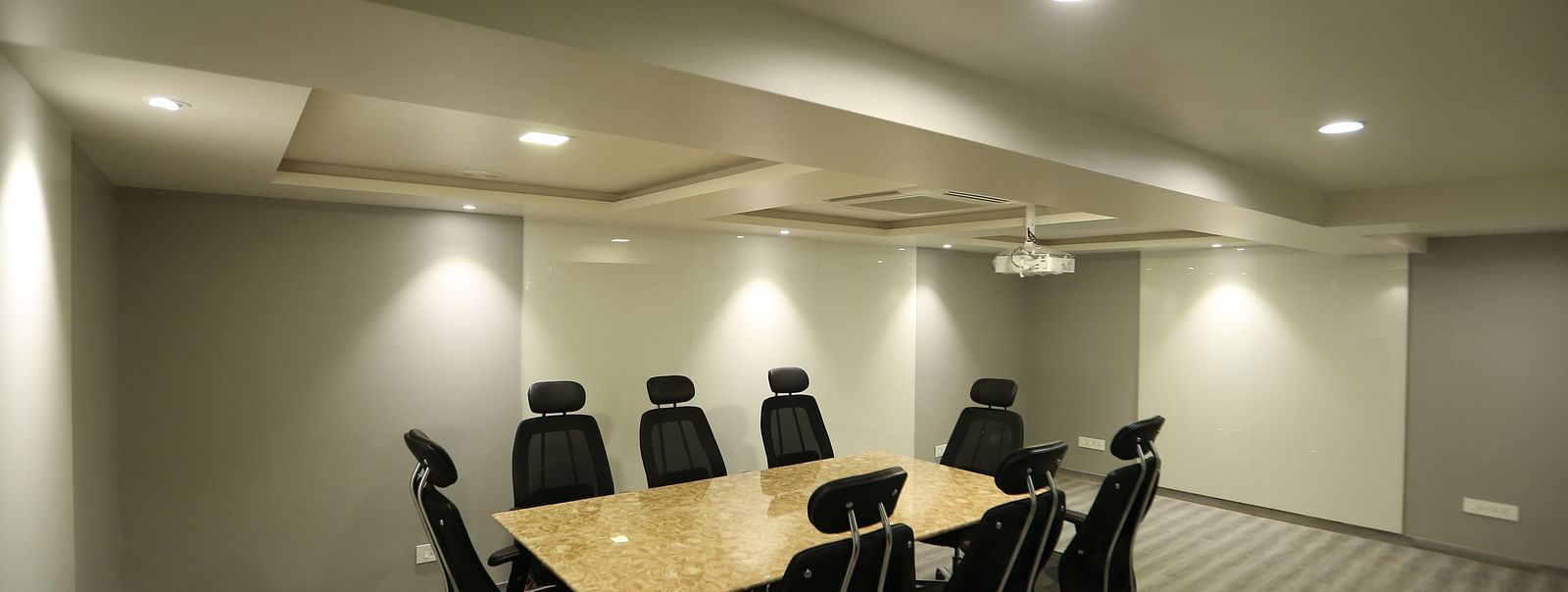 A meeting room setup with a long conference table and chairs - TGI SPS Grand, Coimbatore