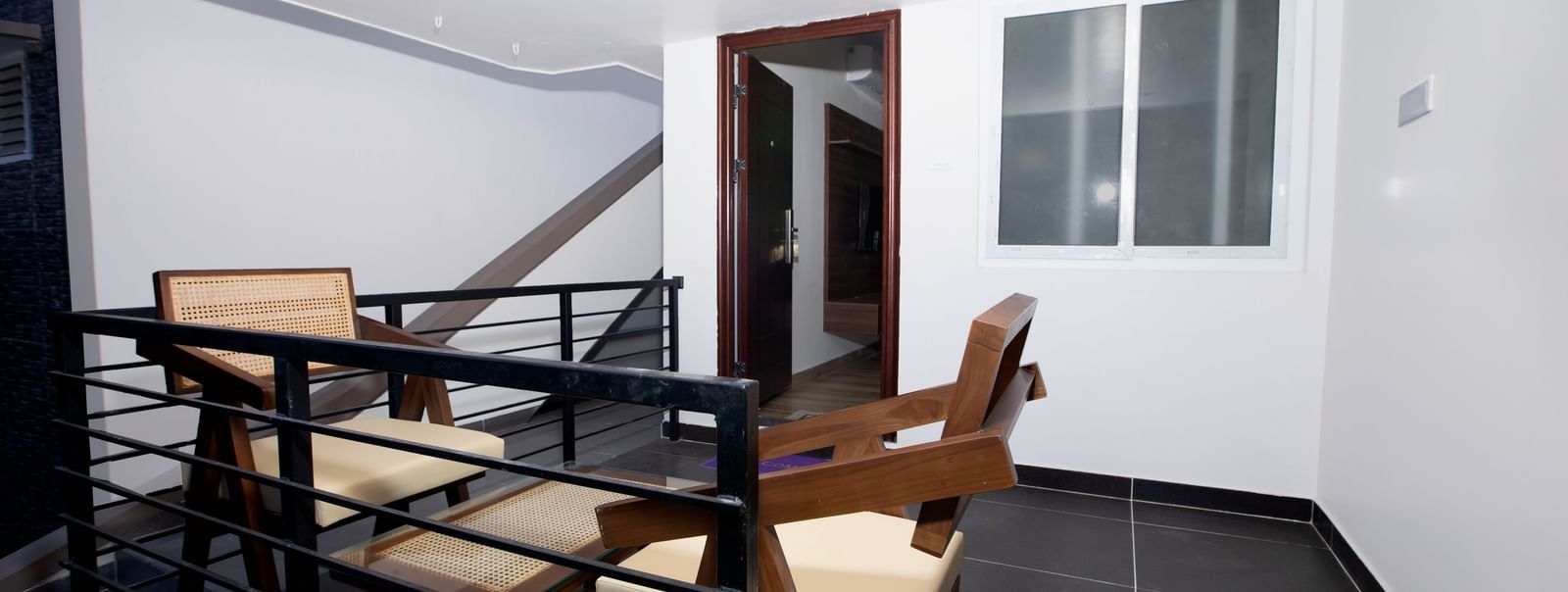 The exterior of the Nature Luxury Room featuring an outdoor seating area with 2 cushioned arm chairs at WOW Naturefull Resorts, Yercaud.