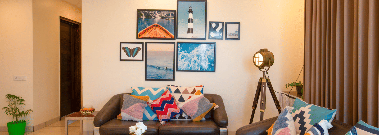 A living room at Perfectstayz Value Shimla (Namah Retreat) with 2 sofas, a coffee table, wall art, a floor lamp, curtains, and an indoor plant.