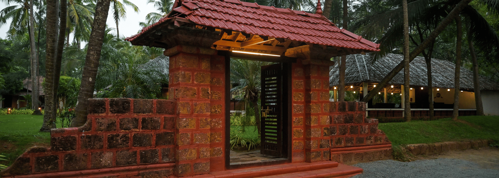 A traditional entrance gate with a tiled roof leading into the grounds of Ayur On The Beach Nattika.