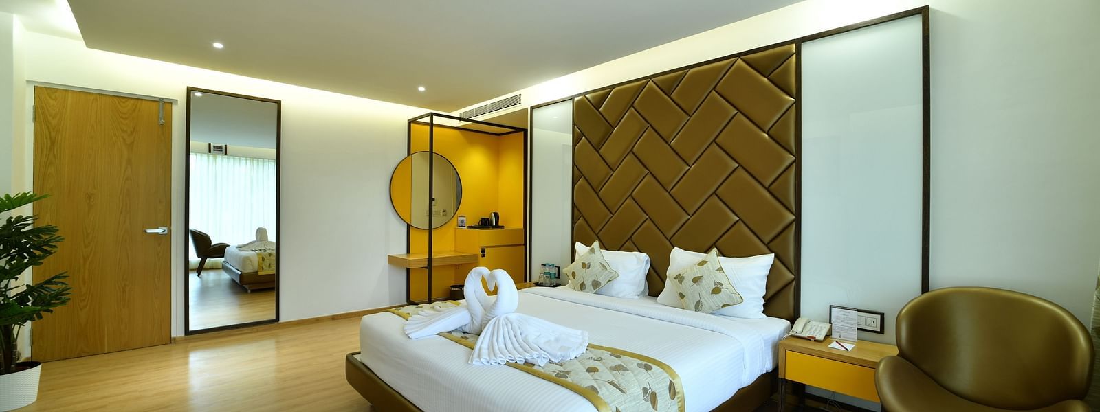 An image of a room with a bed and a golden yellow armchair -The President Hotel, Kumara Park, Bangalore