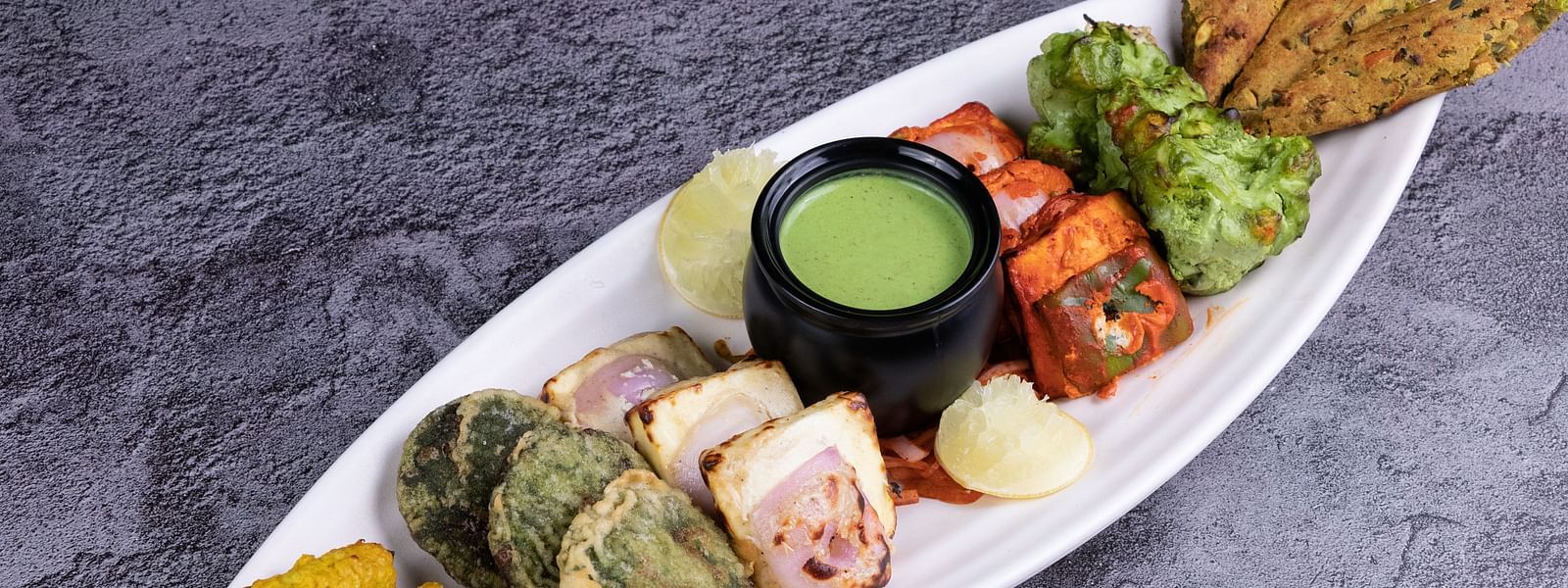 An assorted platter of grilled Indian appetizers accompanied by mint sauce - The President Hotel, Kumara Park, Bangalore