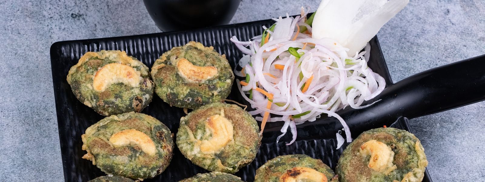 Spinach and cheese stuffed mushrooms served with mint chutney on a black platter - The President Hotel, Kumara Park, Bangalore