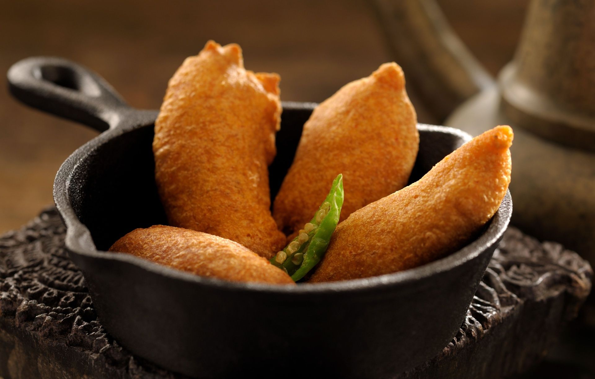 Deep-fried golden Banana Bajji in cast iron pan.