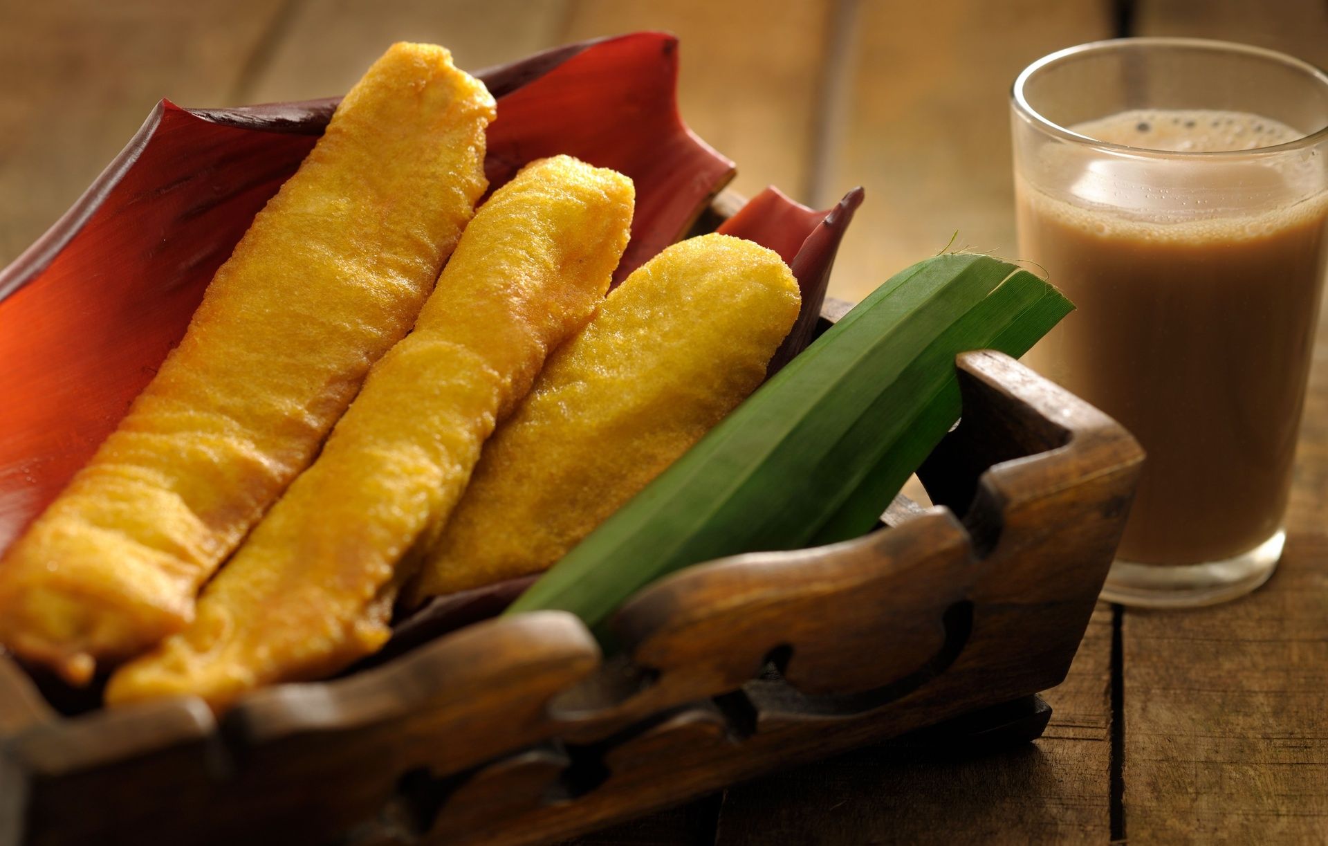 Pazham Pori (banana fritters) with chai on a rustic table.