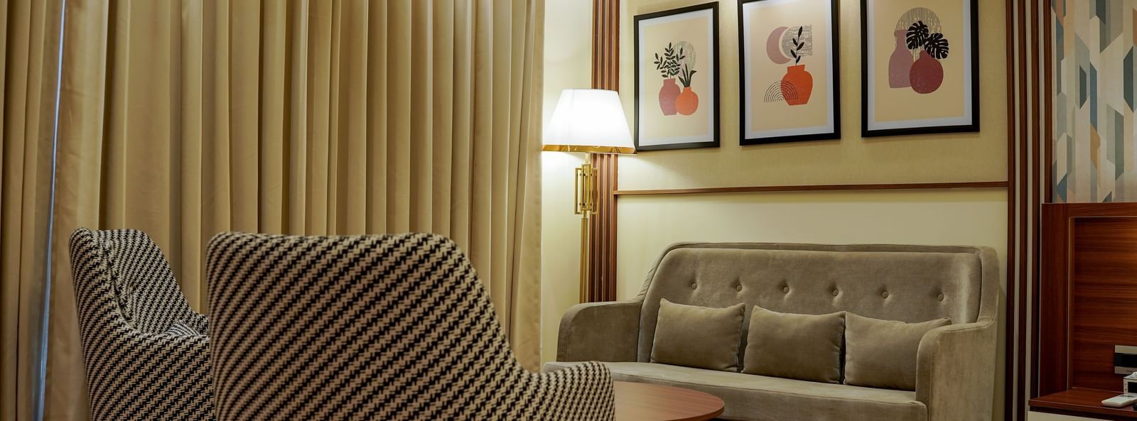 A close-up shot of the separate seating area with a tall lamp in the corner in the premium room at M2 Square by Monday Premium.