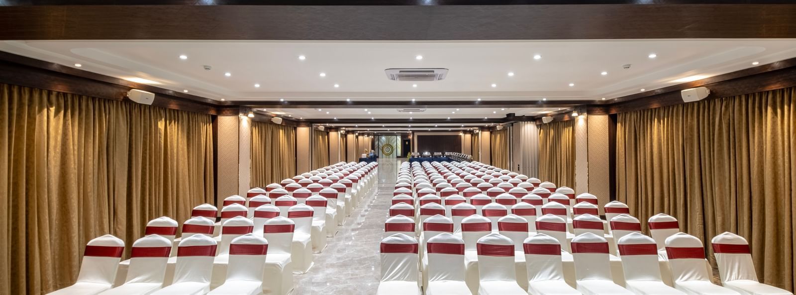 Theatre seating arrangement with ambient lighting at Monday Hotels Amalapuram Heights banquet hall.