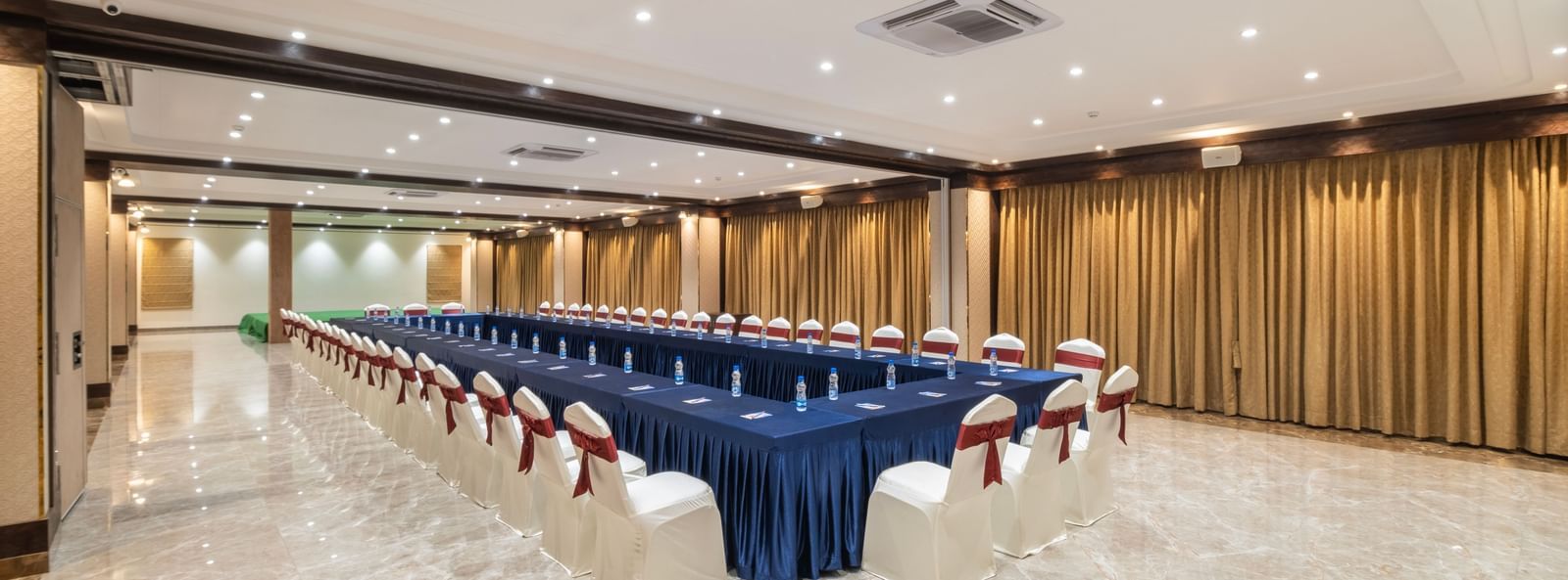 Banquet setup at Monday Hotels Amalapuram Heights with boardroom seating arrangement.
