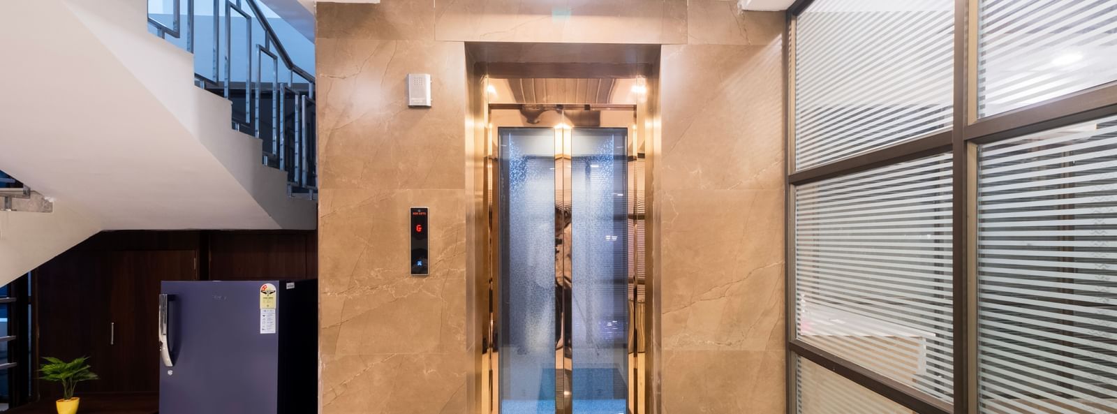 Sleek lift lobby with glass walls polished tiles and elegant modern design at Swarna's The Capital.