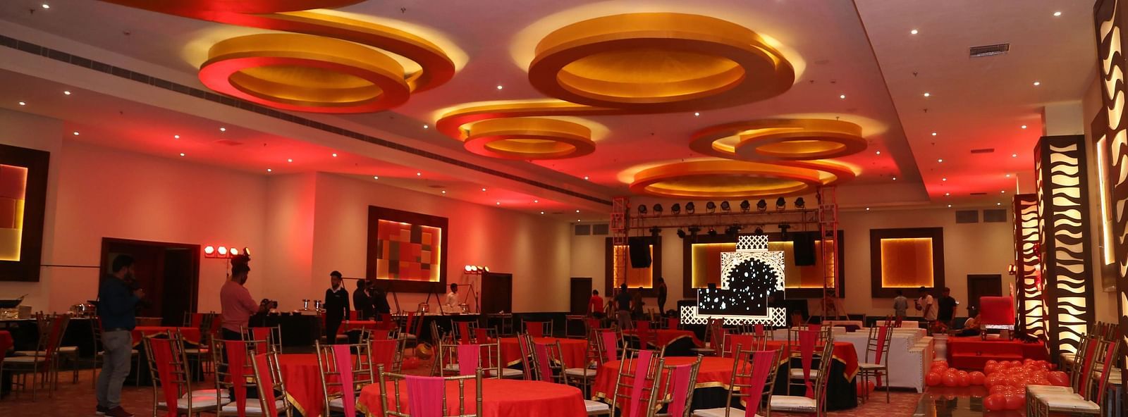 Large hall with ceiling circles, chairs, and stage.