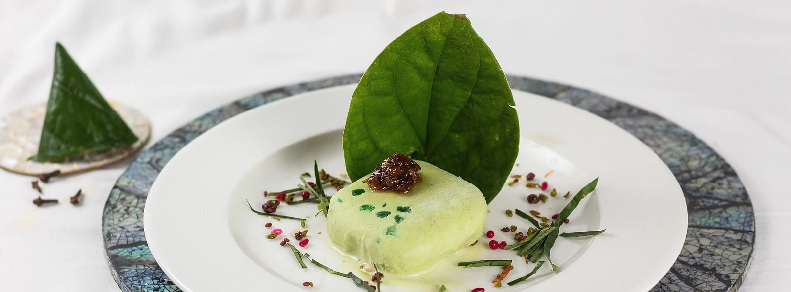 Artistic presentation of a dish with a leaf garnish, culinary creativity.