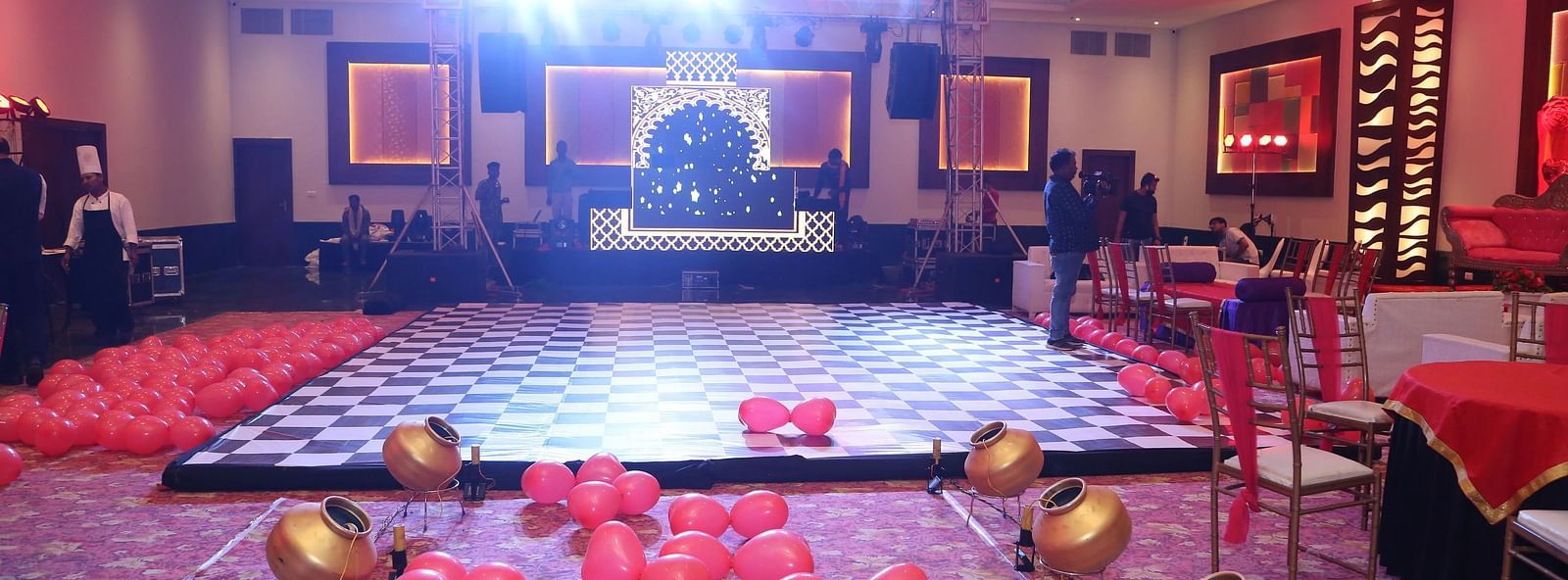 Stage with carpet, bowls, and framed artwork on walls.