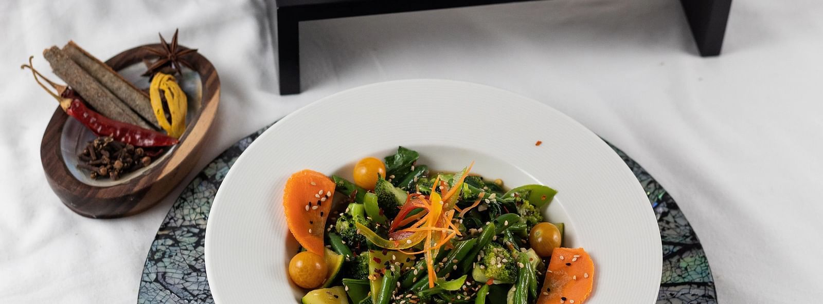 Fresh salad with three colourful dips, presented elegantly, a light and healthy option.