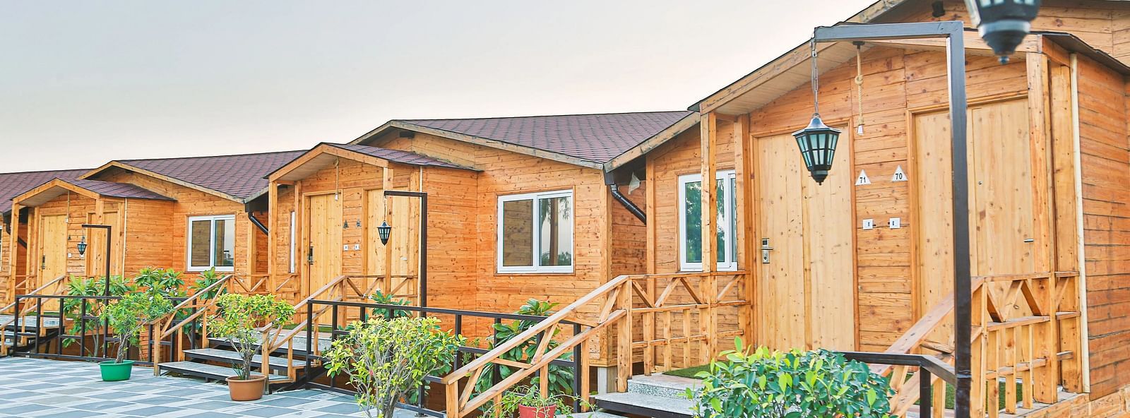 A row of small wooden cabins with green trim.