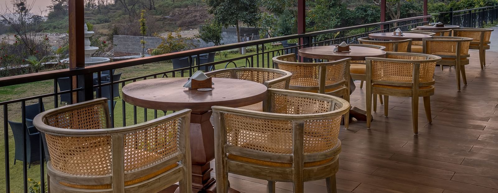 An image of Outdoor seating area with a view of lush trees and mountains at Atman, dharamshala.
