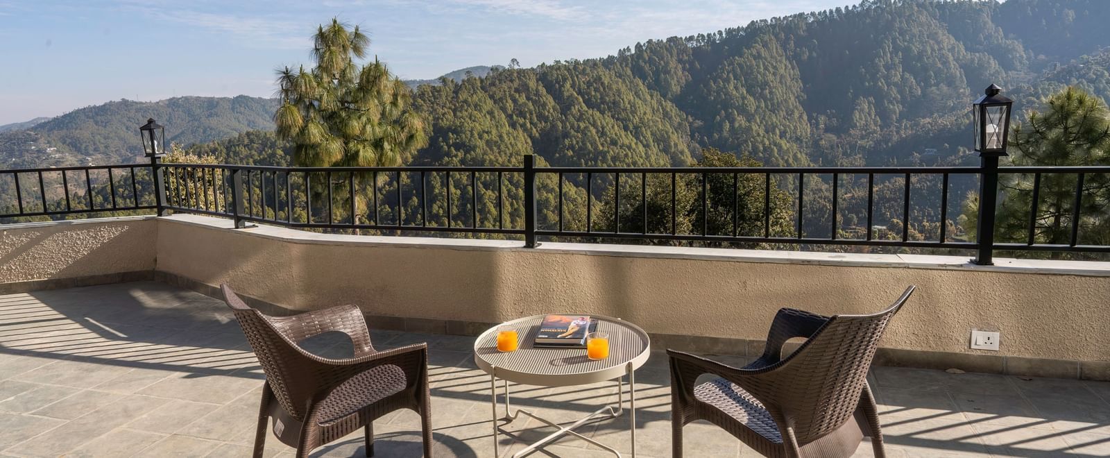 A spacious balcony at The Chamomile Estate, furnished with outdoor seating and offering serene mountain views.