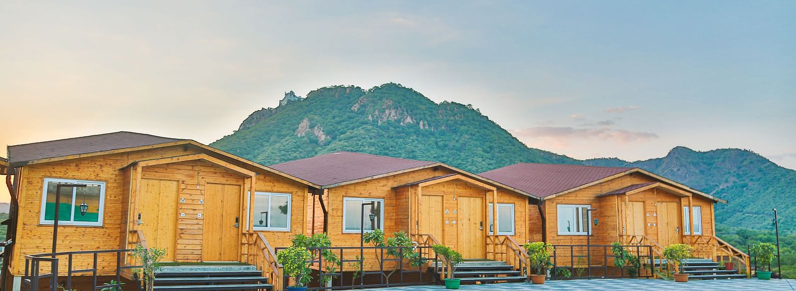 A row of wooden cabins with slanted roofs and windows. - Bamboo Saa Resort & Spa, Udaipur