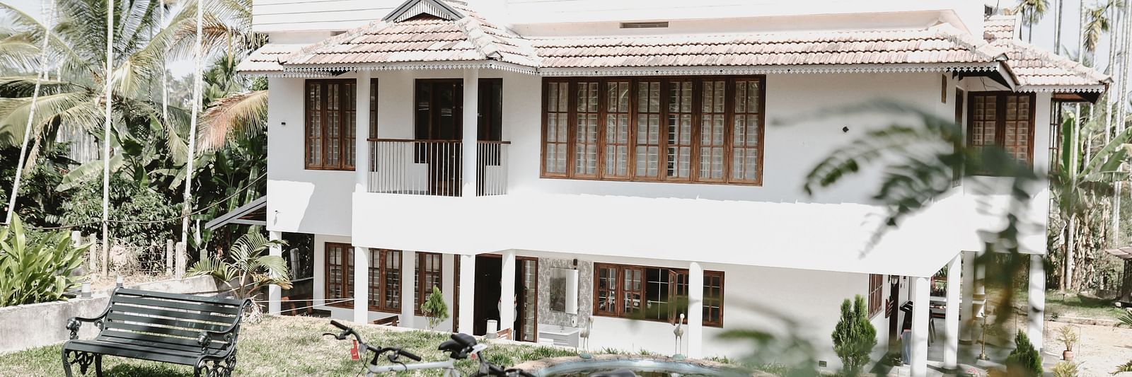 2 bicycles standing in front of the Facade of Ananda Holiday Home, Wayanad