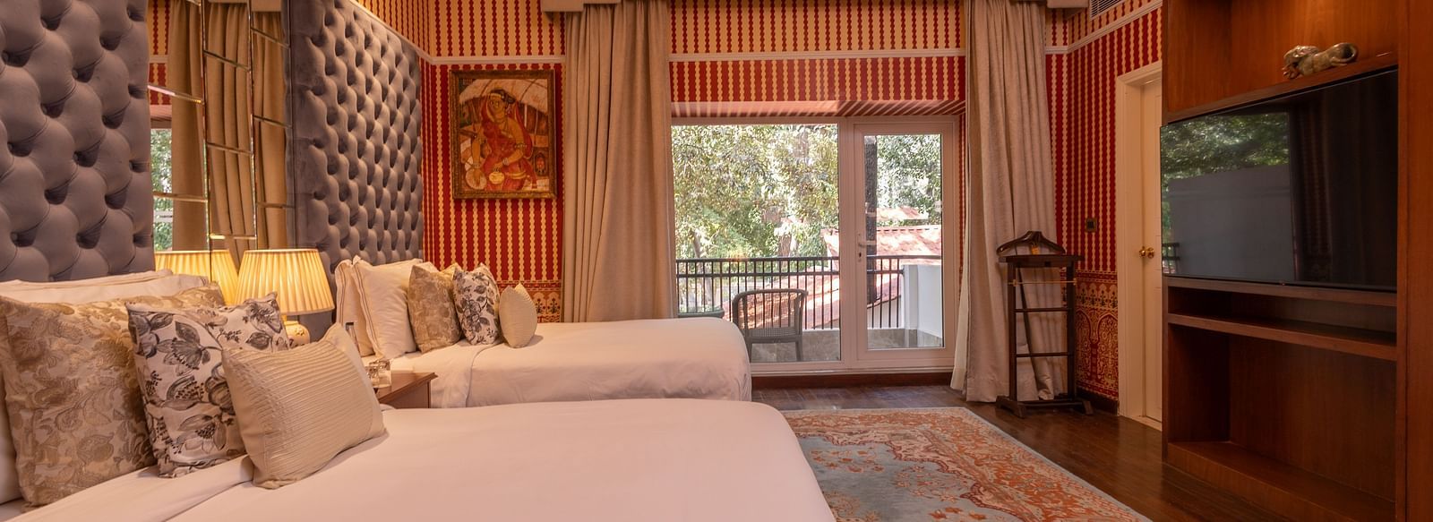 Side view of the spacious Luxury Twin Bed Room with Balcony at The Claridges New Delhi, featuring two separate beds, a stylish candellia hanging