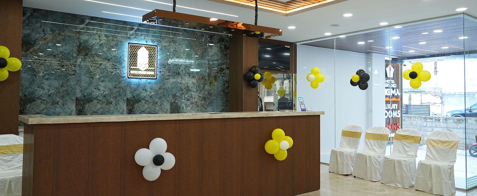 side angle view of the reception area with four chairs kept in the side - Hotel Grand Sigma