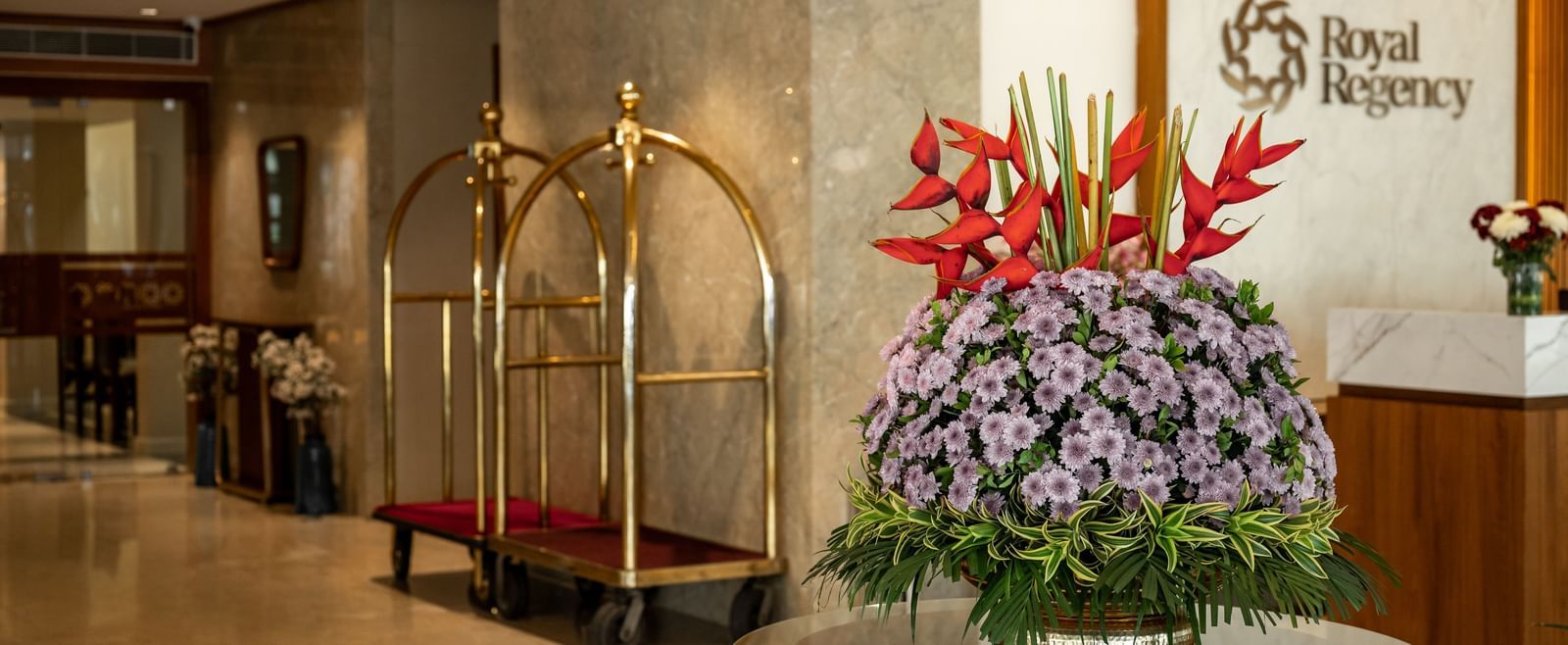 Reception area with floral arrangement and concierge desk at Hotel Royal Regency Chennai