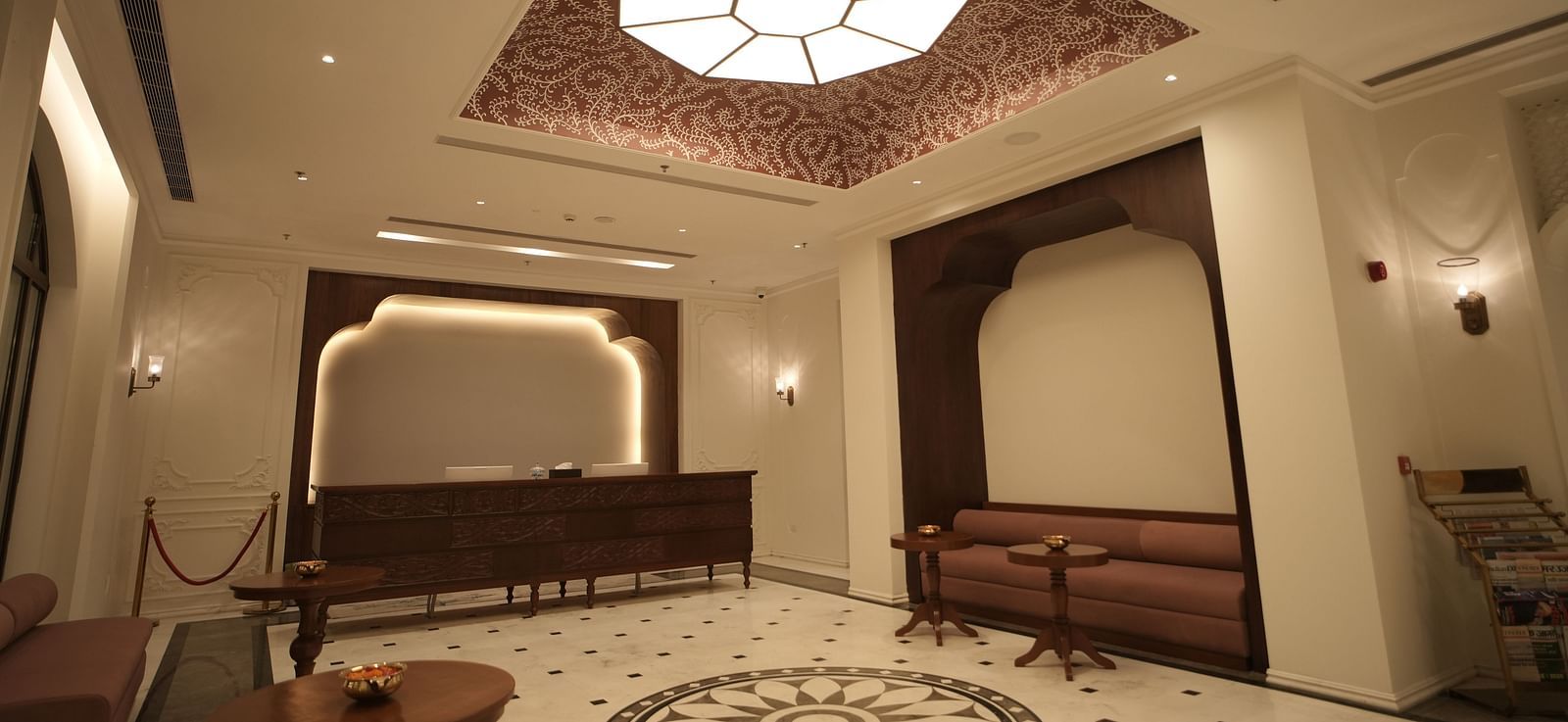 An expansive lobby area at Bhagirathi by RDB Atishay with an atrium on the ceiling featuring intricate patterns painted on it.