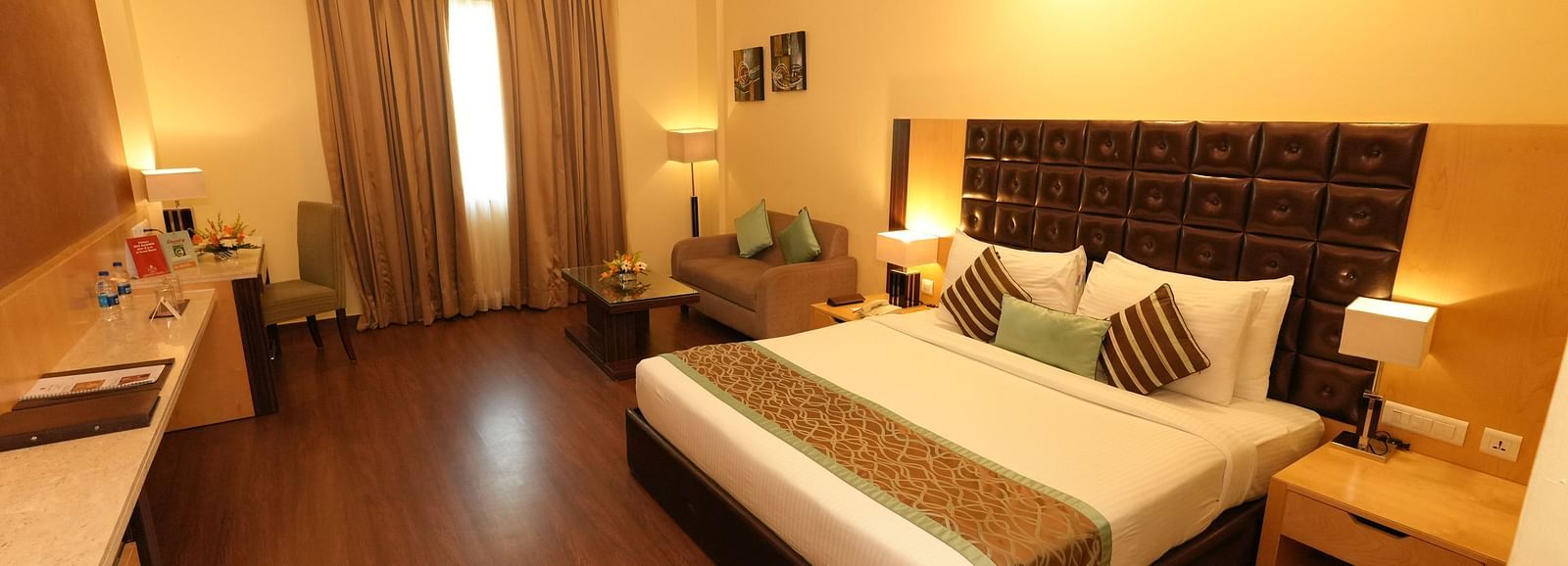 Guest room featuring a large bed and bedside tables - Grand Plaza Lords Inn Jammu
